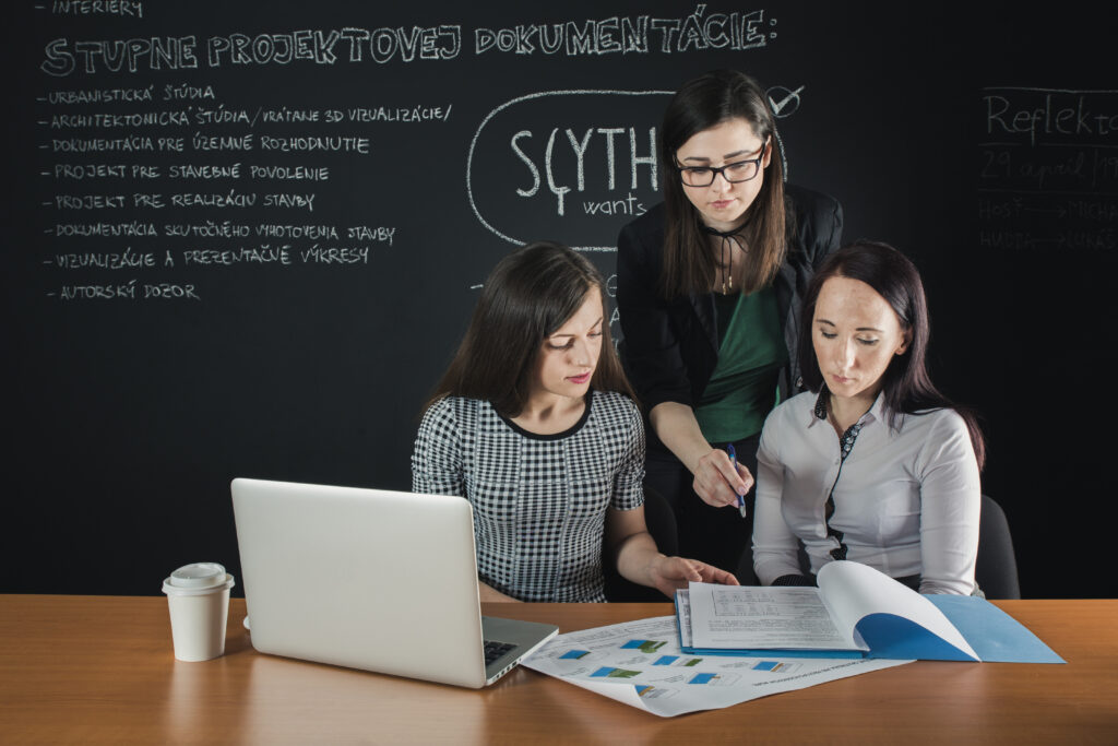 womens discussing business growth through seo in the office with blackboard background